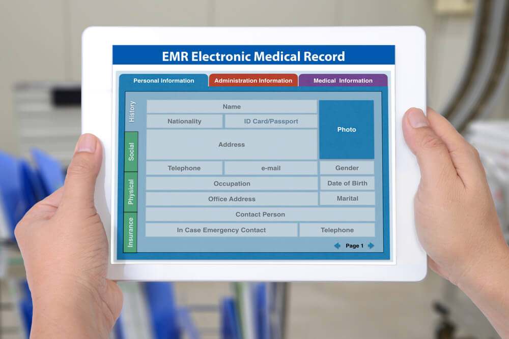 Hands hold a device with a screen for electronic medical record.