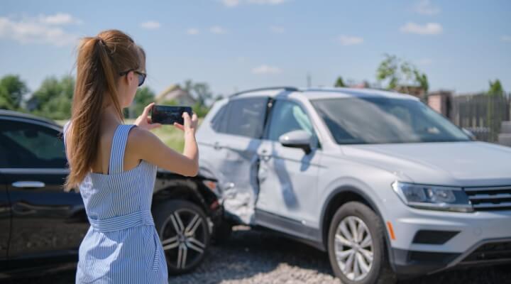 Woman talks on phone to insurance company after an accident.