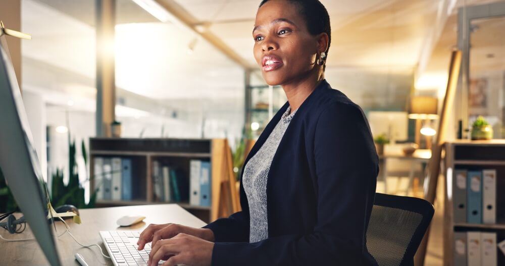 A businesswoman enters mortgage loan data into her computer.