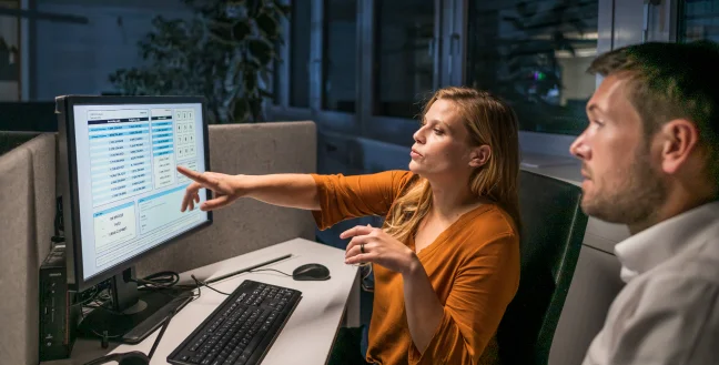 Male and female specialists reviewing the security of a financial services call center.