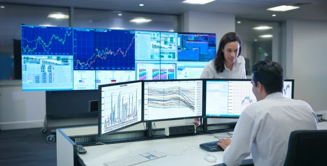 Man and woman reviewing results on screens at a financial services call center.