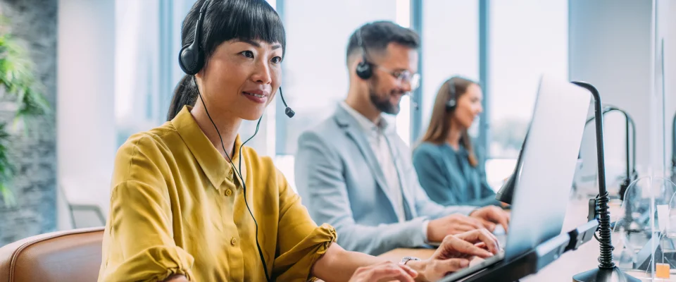 Three agents answering calls at a financial services-focused call center.